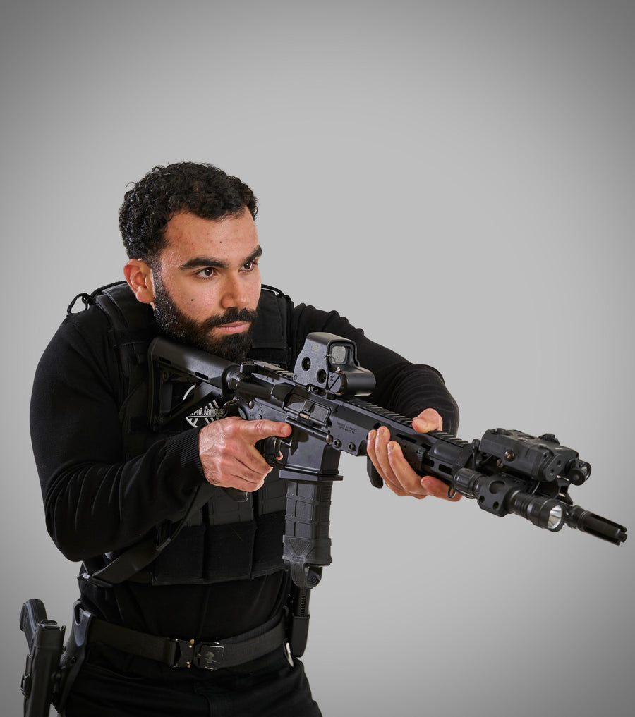Man in tactical gear holding a rifle against a grey background taken at our Sonder SPACT Character Profile Session.