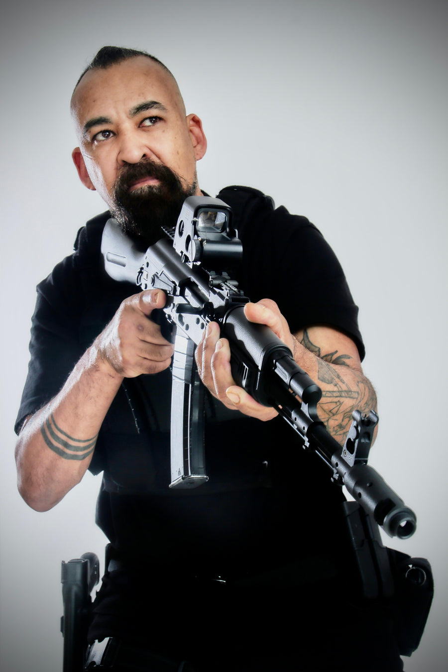Man holding a rifle against a plain background taken at our Sonder SPACT Character Profile Session.