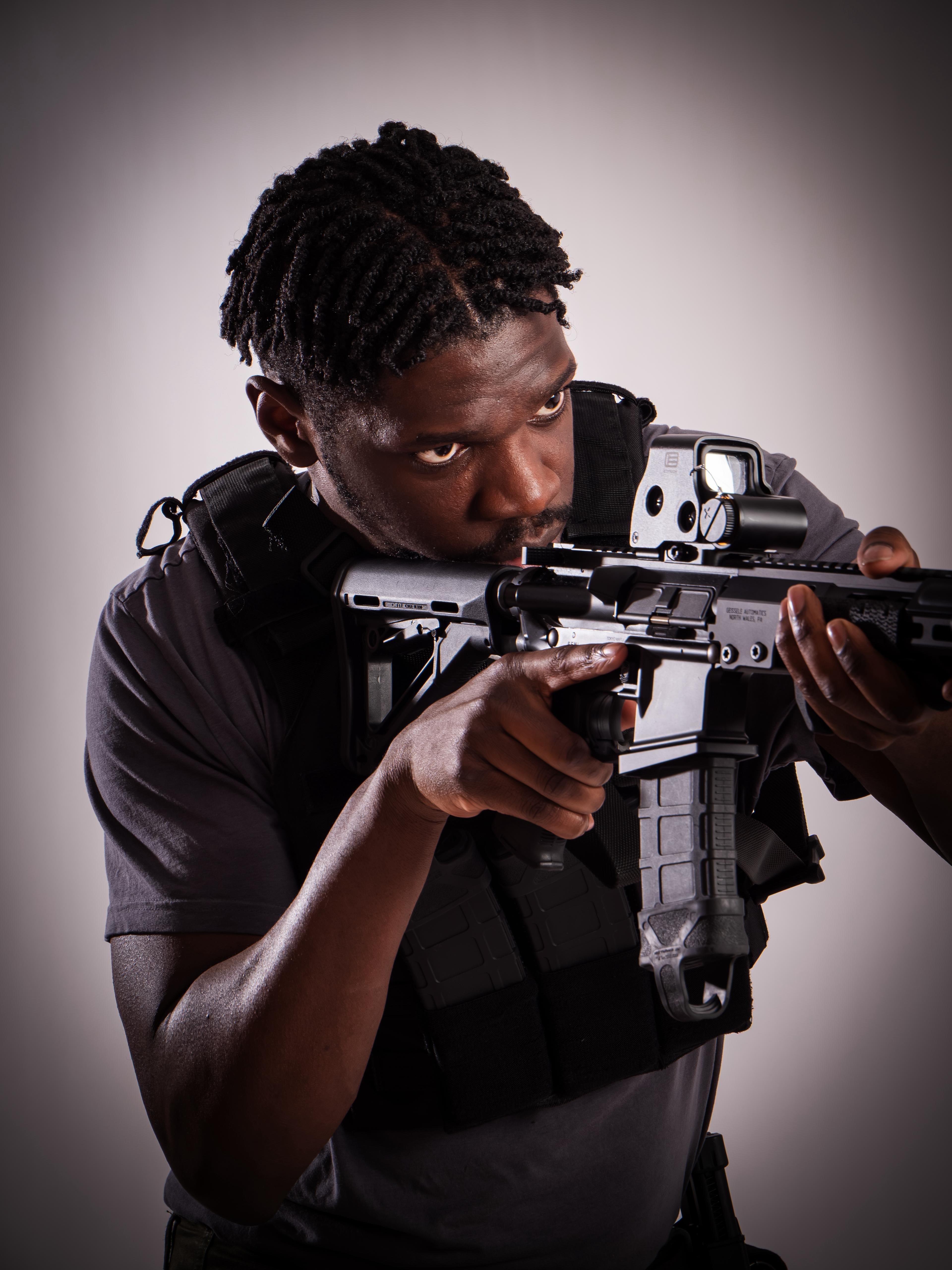 Person holding a rifle against a neutral background taken at our Sonder SPACT Character Profile Session.