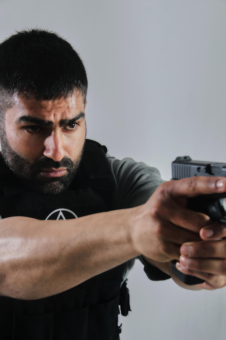 Man holding a gun against a plain background taken at our Sonder SPACT Character Profile Session.