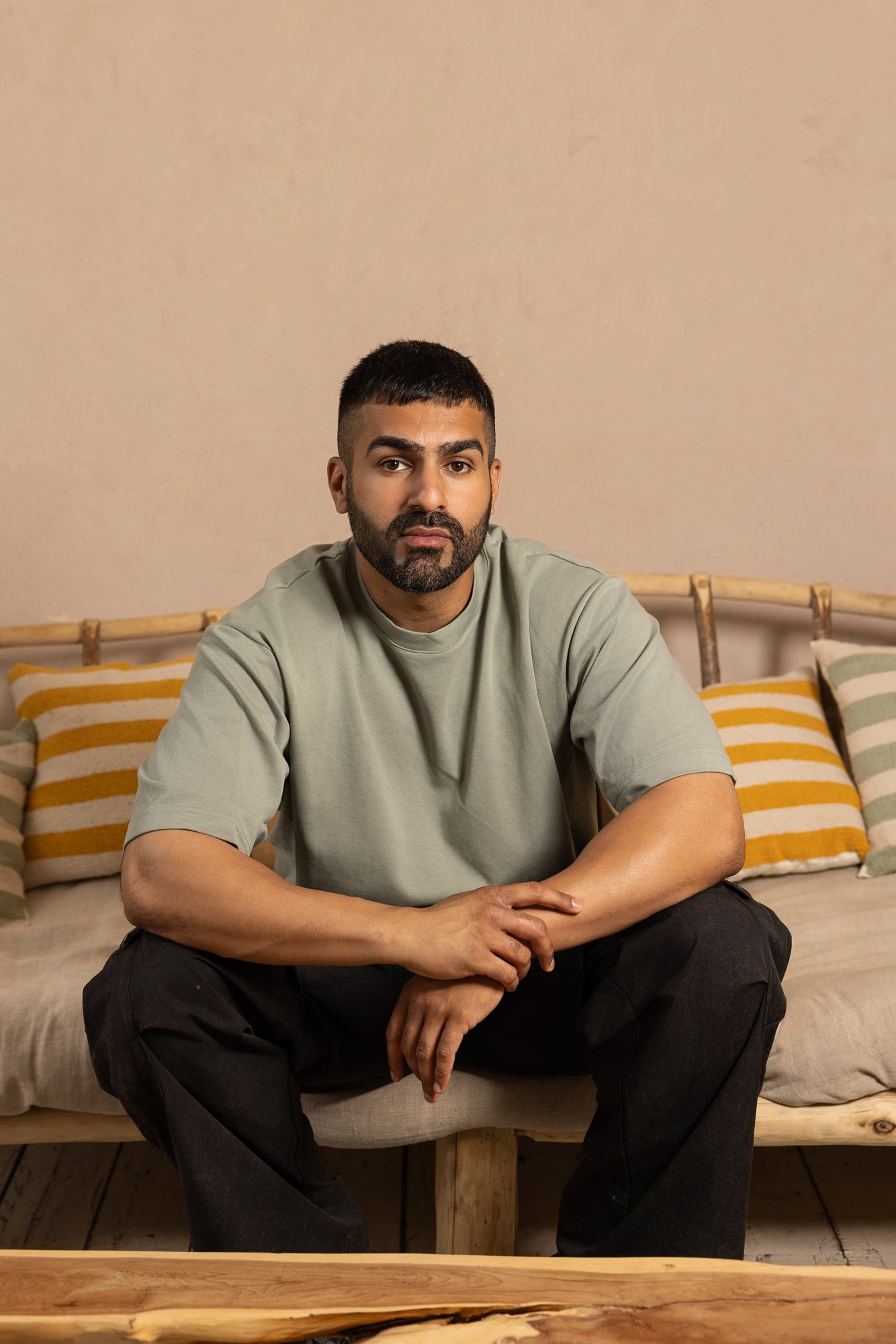 Man sitting on a couch with striped pillows in a casual setting