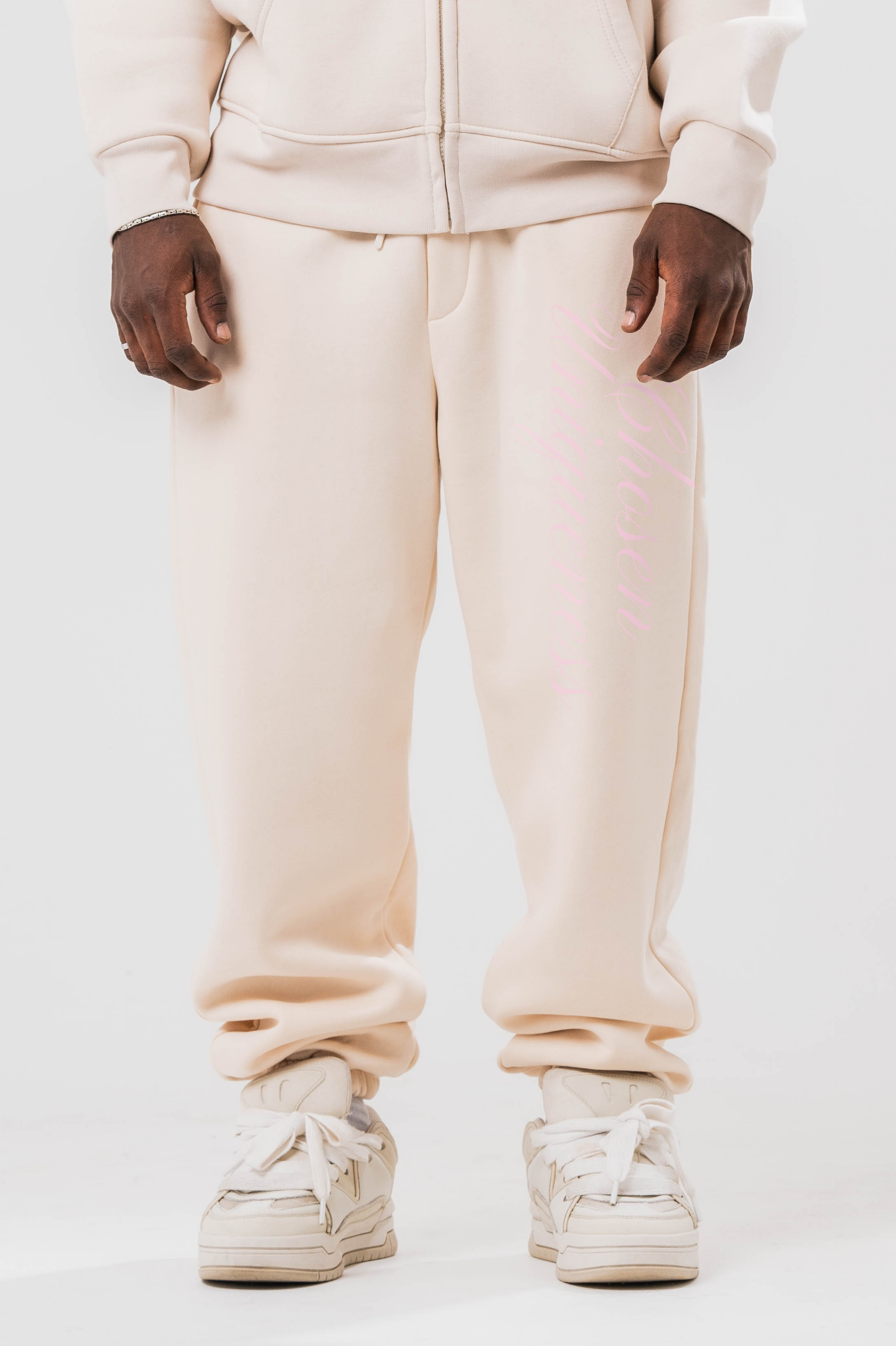 Male model wearing the Sonder Beige Oversized zip hoodie with the oversized joggers. Standing in front of a light grey background.