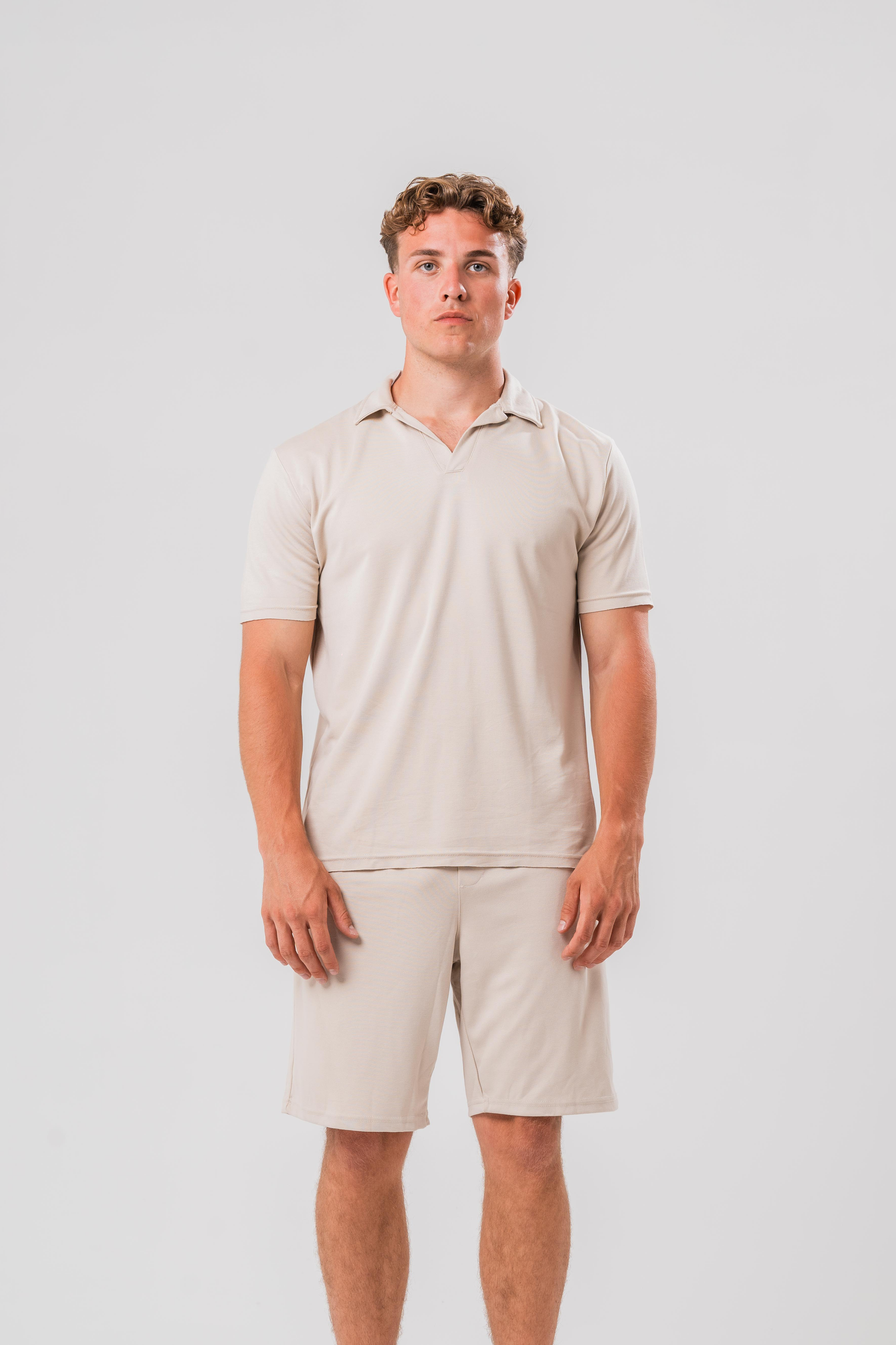 Male model wearing the Sonder Beige Summer Set including the Polo Shirt and shorts, in front of a light grey background