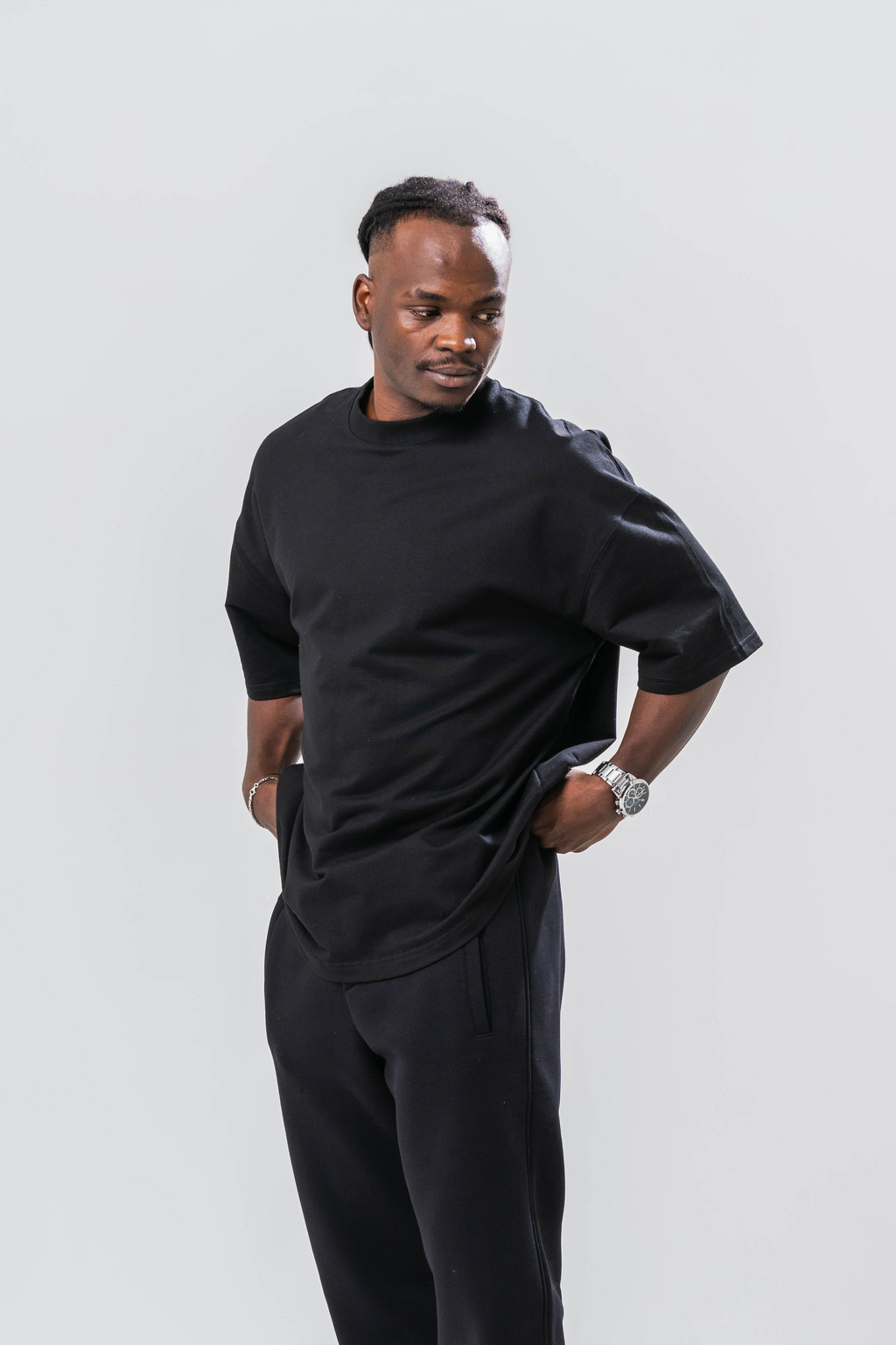Male model wearing the Sonder Signature Series Black oversized t-shirt and black joggers, in front of a light grey background
