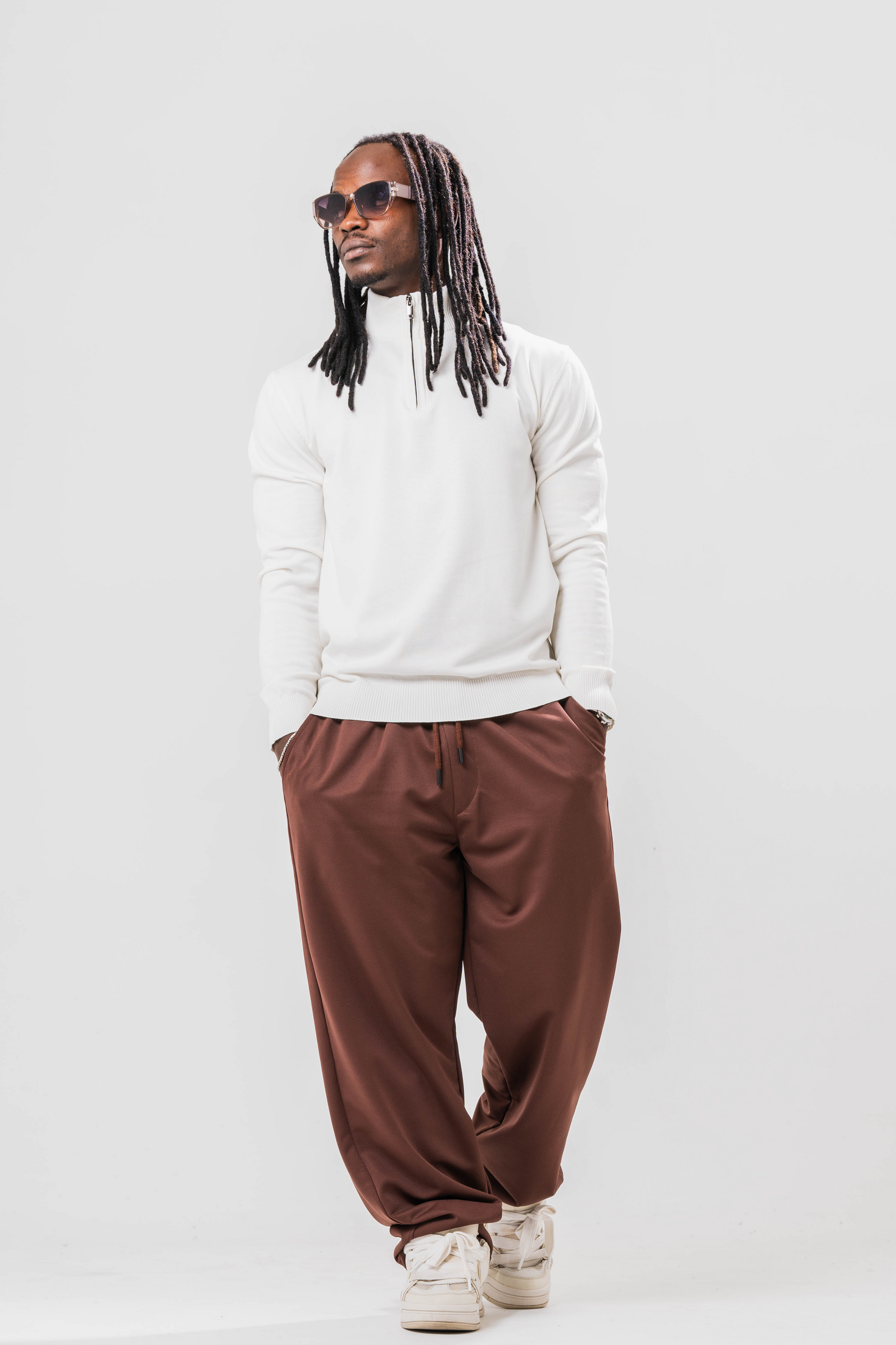 Male model wearing the Sonder Cream Quarter Zip paired with our relaxed brown joggers