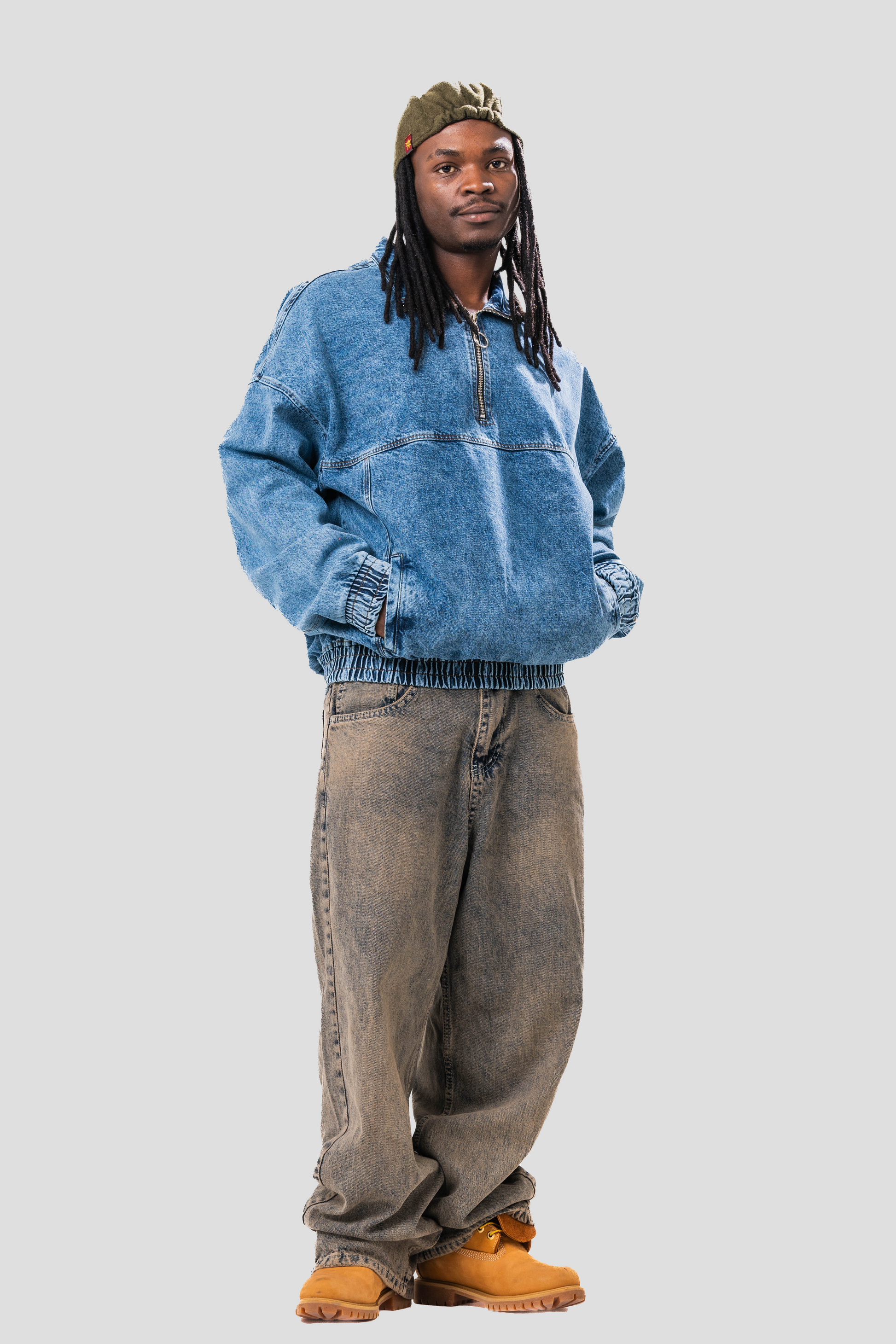 Male model wearing our Denim Quarter Zip Pullover, also wearing a hat and baggy jeans