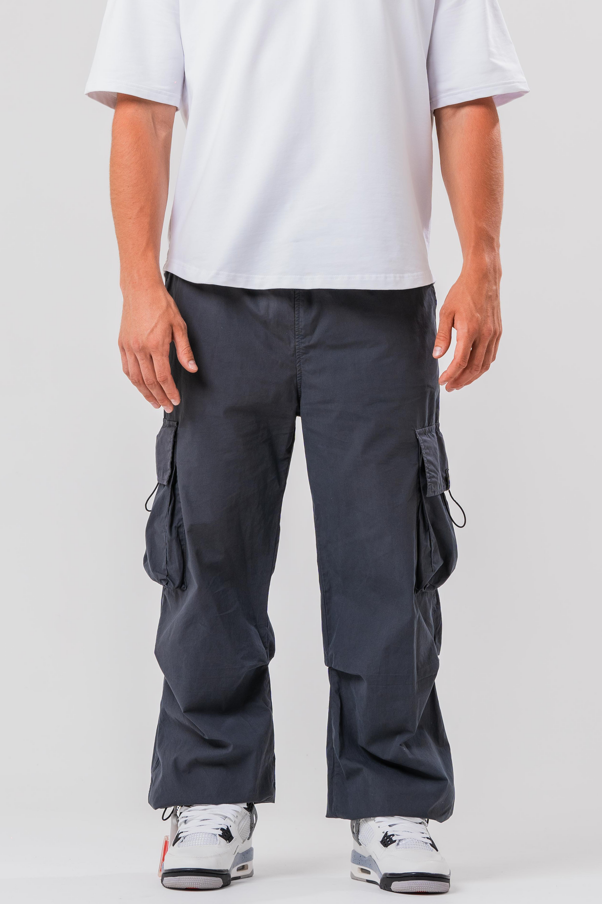 Male model wearing the Sonder Grey Oversized Cargo Pants and Sonder White Oversized Graphic Cowboy T-Shirt. In front of light grey background.