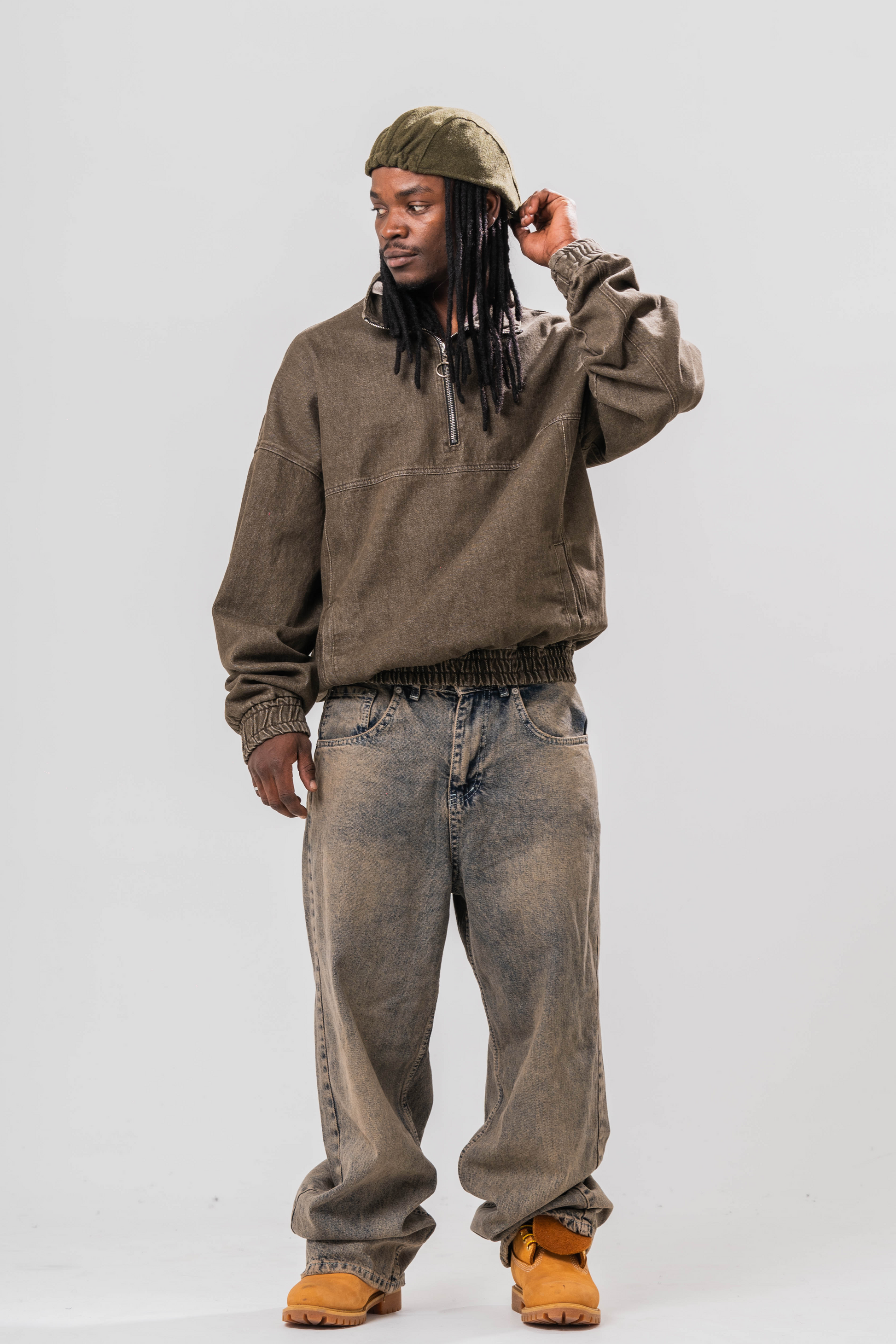 Male model wearing our Khaki Denim Quarter Zip Pullover, also wearing a hat and baggy jeans