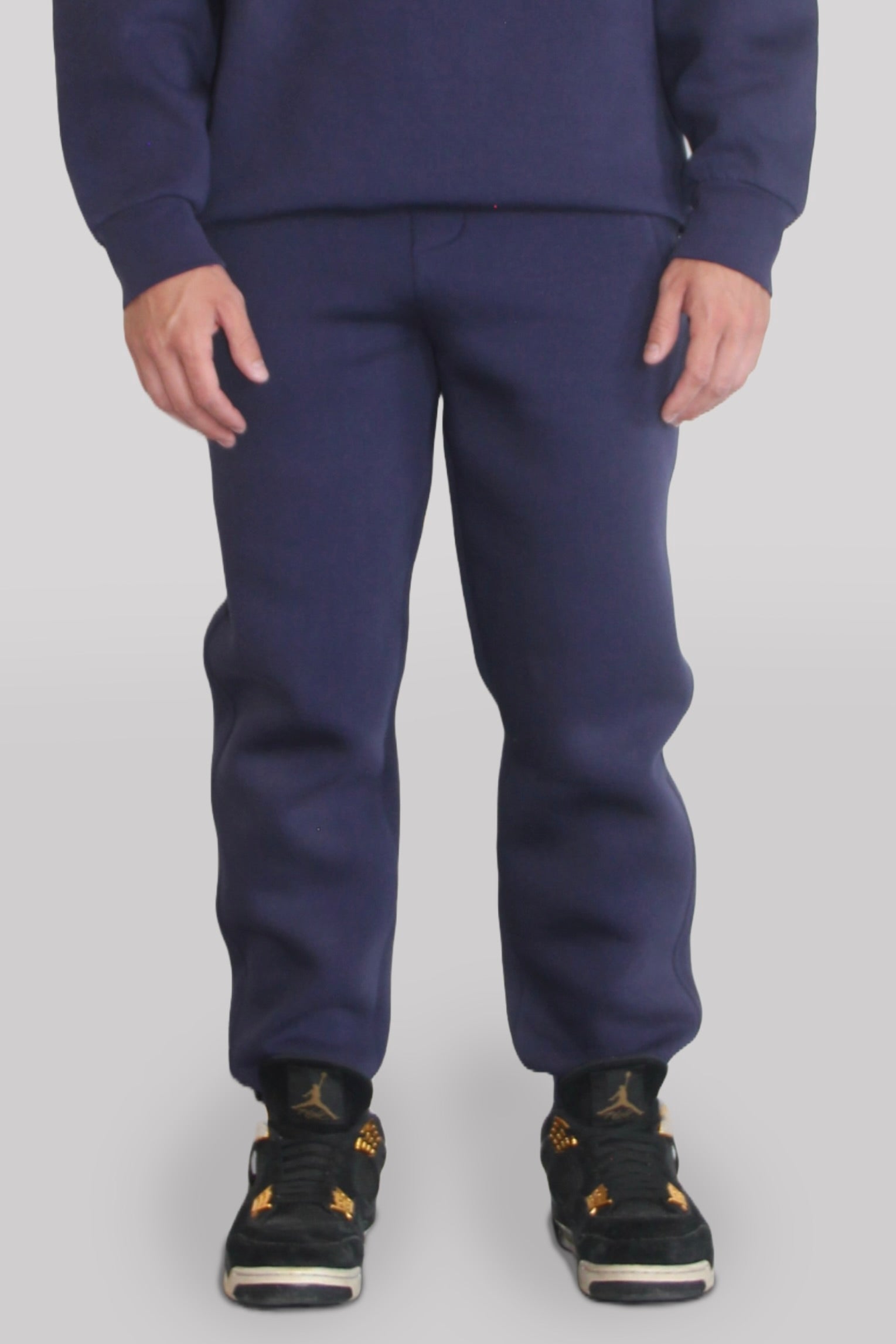 Male model wearing the Sonder Navy Signature Series Sweatpants paired with the Navy Signature Series Sweatshirt. In front of a light grey background.