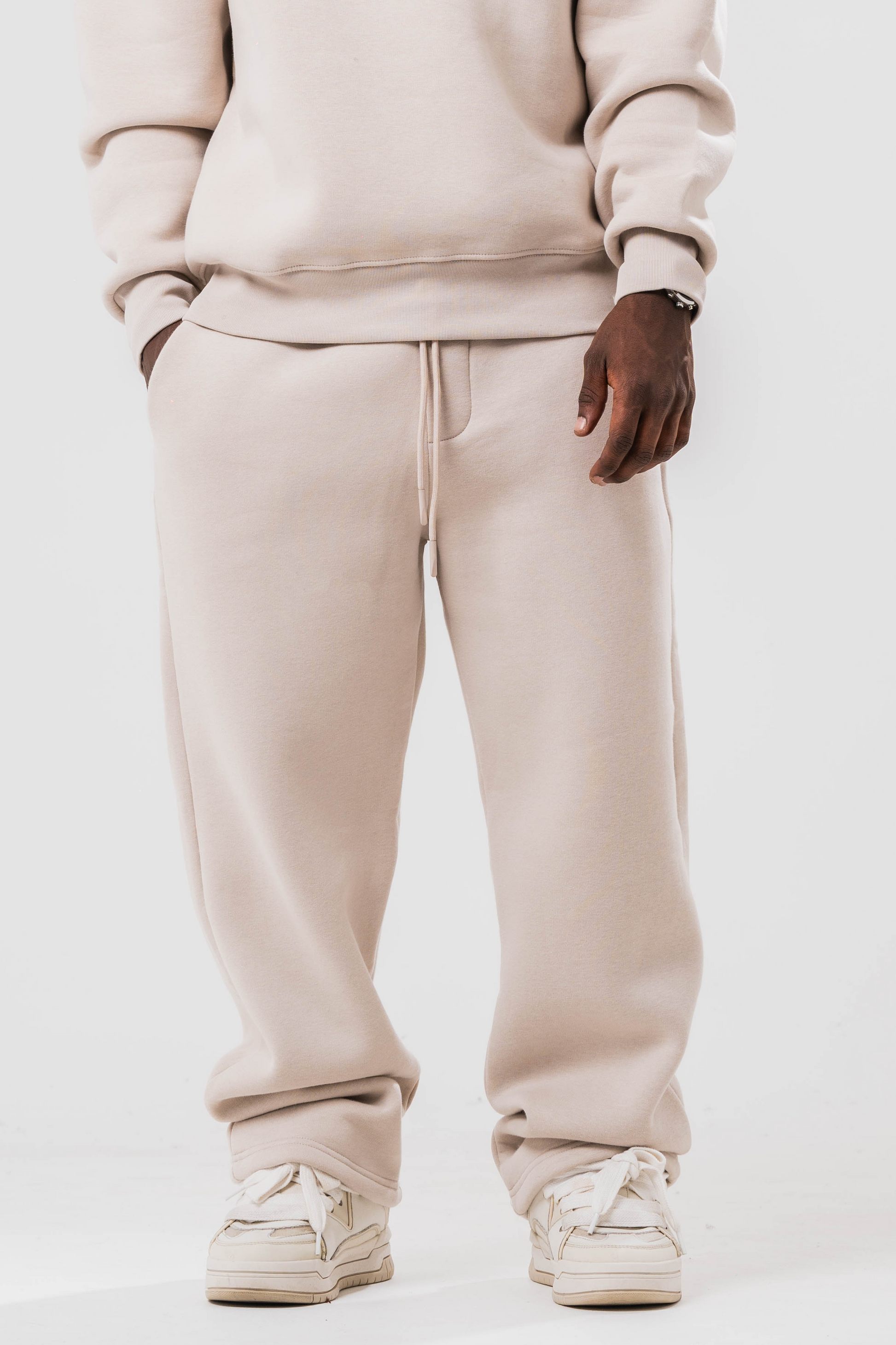 Male model wearing the Sonder Off-White Oversized sweatshirt with the oversized joggers. Standing in front of a light grey background.