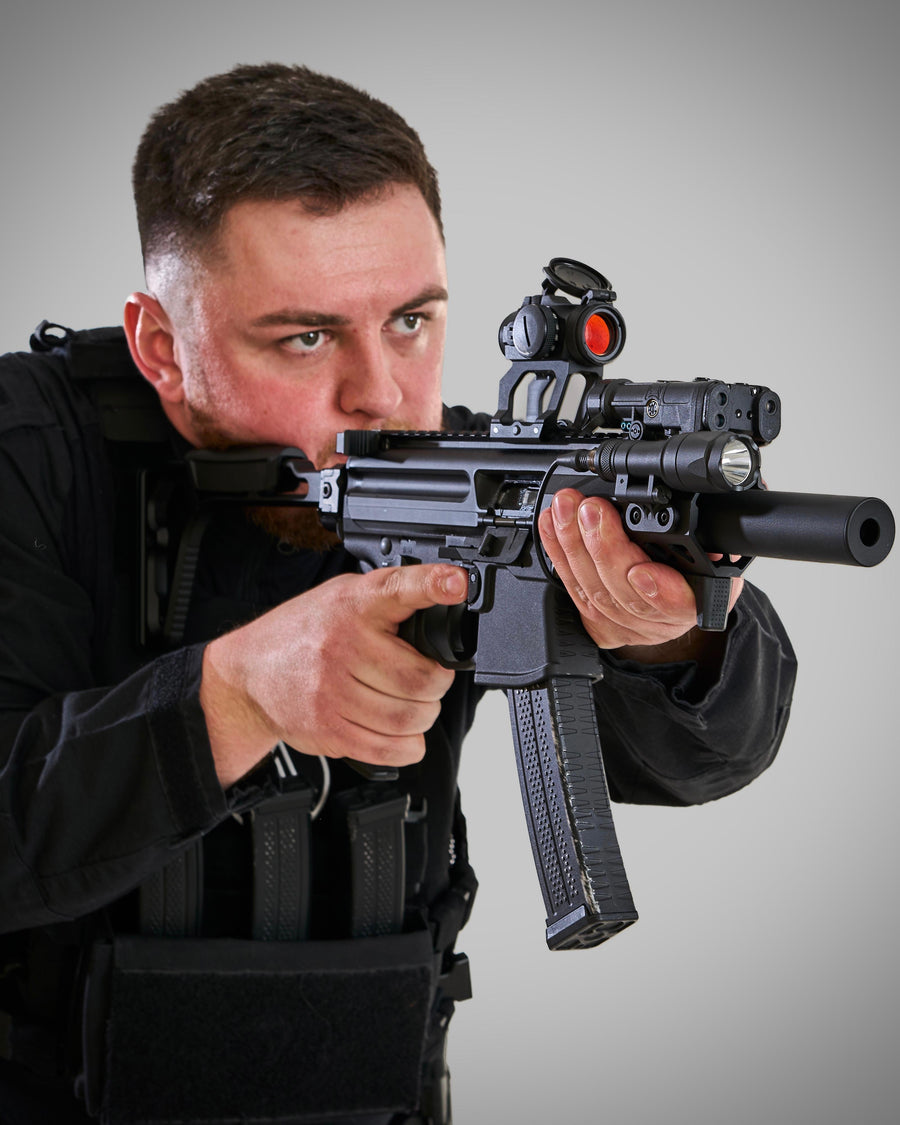 Person holding a rifle with a scope against a grey background taken at our Sonder SPACT Character Profile Session.